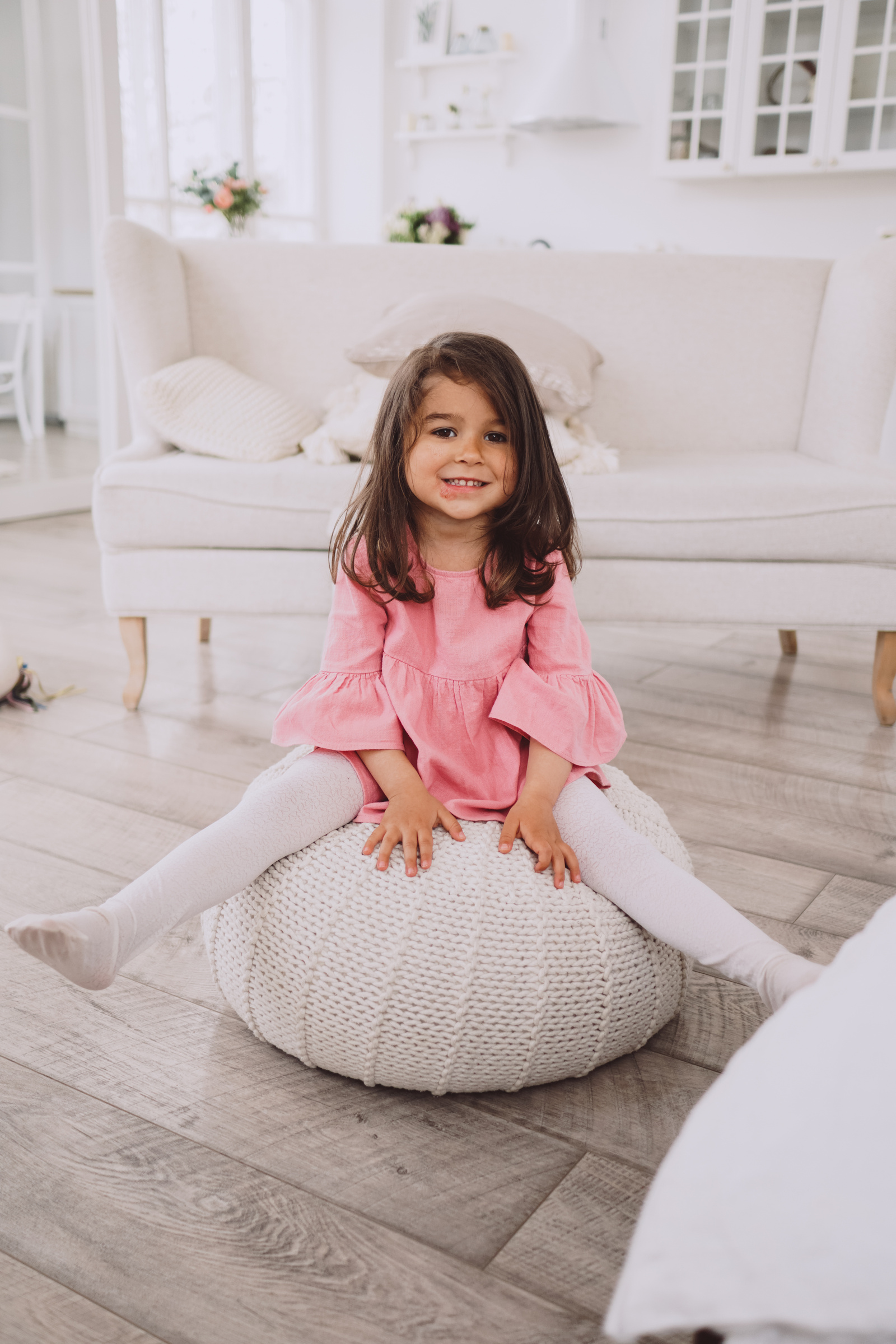 Little Girl Sitting on a Cushion in the Living Room
